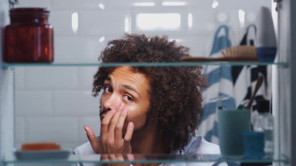 Ver Través Gabinete Baño Hombre Joven Aplicando Crema Hidratante Bajo — Vídeos de Stock