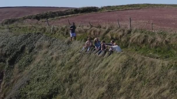 Drone Shot Grupy Przyjaciół Spacerujących Wzdłuż Nadmorskiej Ścieżki Zatrzymując Się — Wideo stockowe