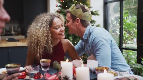 愛するカップルはクリスマスランチのためにテーブルに座っている友人と自宅でささやき合います スローモーションで撮影 — ストック動画