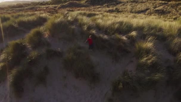 Drohnenschuss Eines Kleinen Jungen Der Sommerurlaub Sanddünen Gegen Die Gleißende — Stockvideo