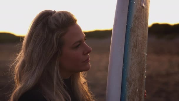 Ung Kvinna Våtdräkt Stående Stranden Vid Solnedgången Håller Surfbräda Sommarsemester — Stockvideo