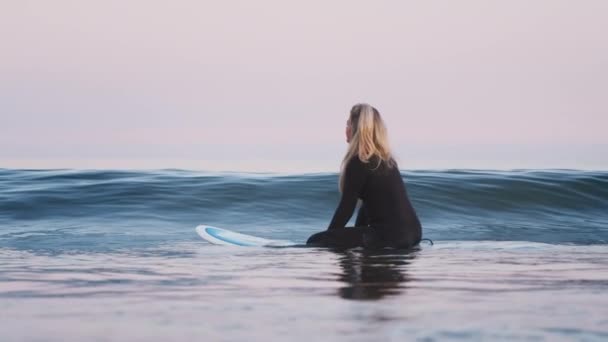 Mujer Surfista Vistiendo Traje Neopreno Flotando Tabla Surf Mientras Las — Vídeo de stock