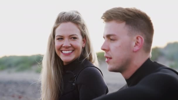 Pareja Con Trajes Neopreno Sentada Tabla Surf Mirando Hacia Océano — Vídeo de stock