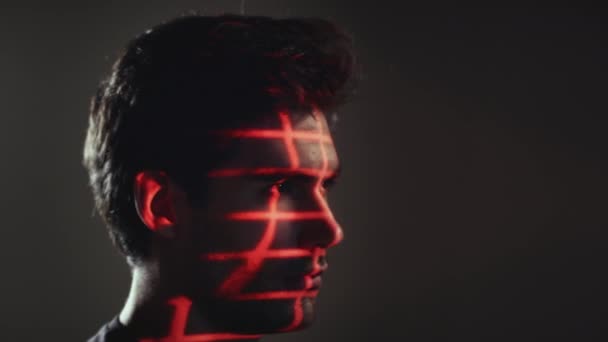 人間として顔認識技術の概念は カメラに目を向ける前に スタジオで目に投影された赤いグリッドを持っている スローモーションで撮影 — ストック動画