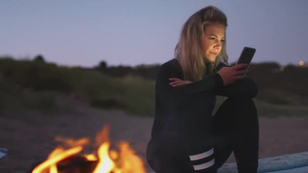 Mujer Vacaciones Verano Sentada Junto Una Fogata Playa Usando Teléfono — Vídeos de Stock