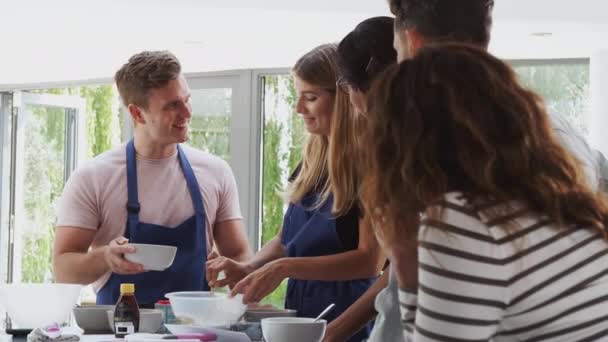 Yetişkin Öğrencilerin Olduğu Bir Öğretmen Mutfakta Aşçılık Kursunda Malzemeleri Karıştırıyor — Stok video