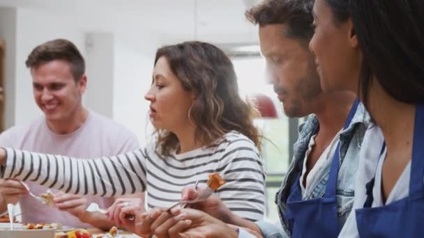 一组男人和女人一起坐在桌旁享用烹调课上准备的饭菜 慢动作拍摄 — 图库视频影像