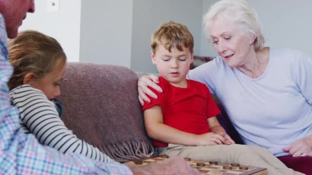 Abuelos Casa Con Nietos Divirtiéndose Jugando Juego Mesa Tradicional Las — Vídeos de Stock