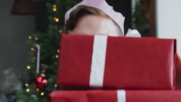 Portret Mężczyzny Noszącego Papierowy Kapelusz Niosący Stos Prezentów Świątecznych Stojących — Wideo stockowe