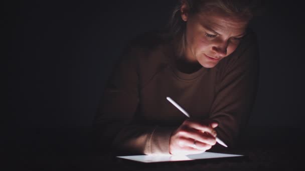 妇女在夜间用手写笔在数字平板电脑上画画 动作缓慢 — 图库视频影像