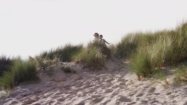 Twee Kinderen Rennen Springen Zandduinen Winter Strand Vakantie Geschoten Slow — Stockvideo