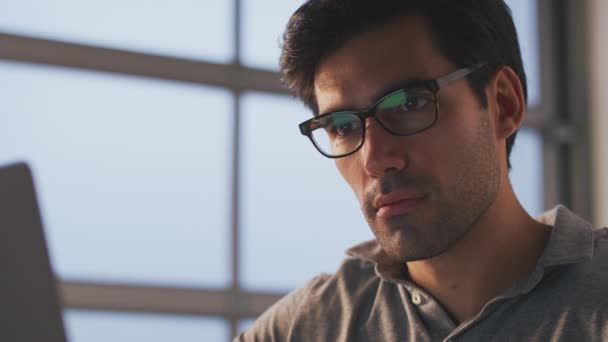 사무실에서 책상에 랩탑을 사용하여 일하는 사업가가 안경을 안약을 천천히 찍는다 — 비디오