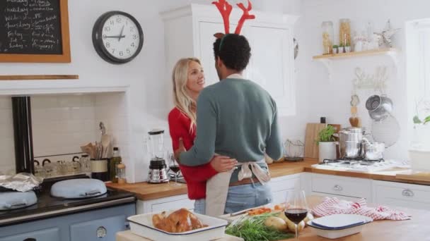 在准备圣诞大餐的时候 男人们穿着华丽的连衣裙 驯鹿的鹿角在厨房里跳舞亲吻 — 图库视频影像