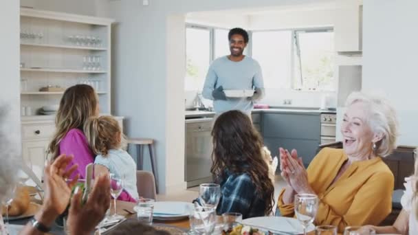 Vader Serveert Maaltijd Aan Multi Generatie Familie Zitten Rond Tafel — Stockvideo