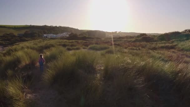 在炎炎烈日下的暑假里在沙丘中玩耍的小女孩的无人驾驶镜头 — 图库视频影像