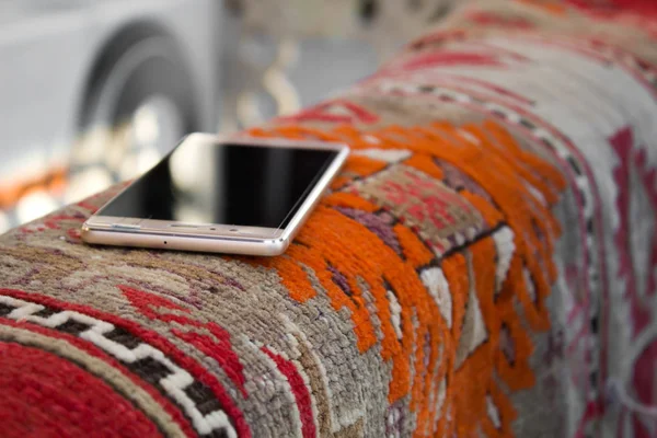 Macro closeup of smartphone, forgotten lying on carpet at park