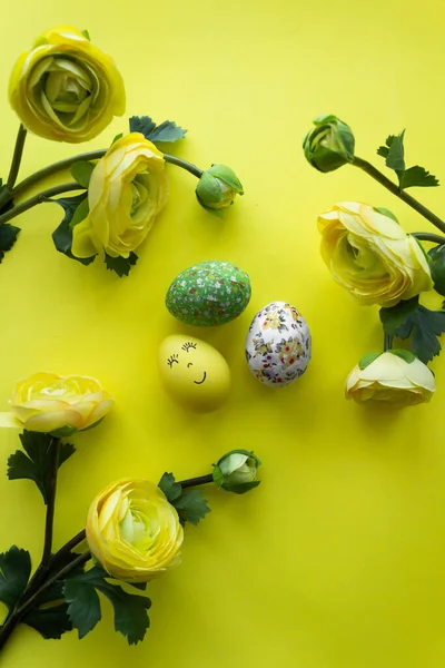 Joyeux jour de Pâques autour de fleurs jaunes avec oeuf souriant jaune sur un fond jaune — Photo