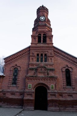 Kırmızı tuğlalı ev ve yeşil ağaçlı ve ilginç binaları olan bir şehir.