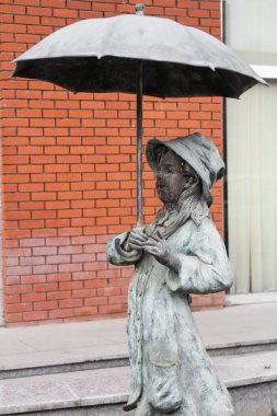 Kırmızı tuğlalı ev ve yeşil ağaçlı ve ilginç binaları olan bir şehir.