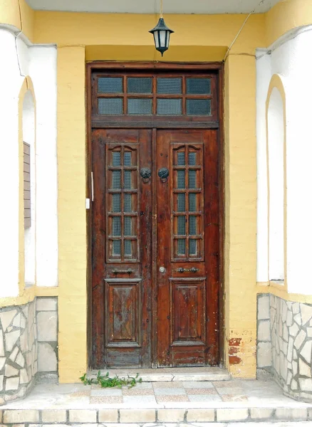 A porta de entrada em uma casa de pedra e uma aldeia nas montanhas — Fotografia de Stock