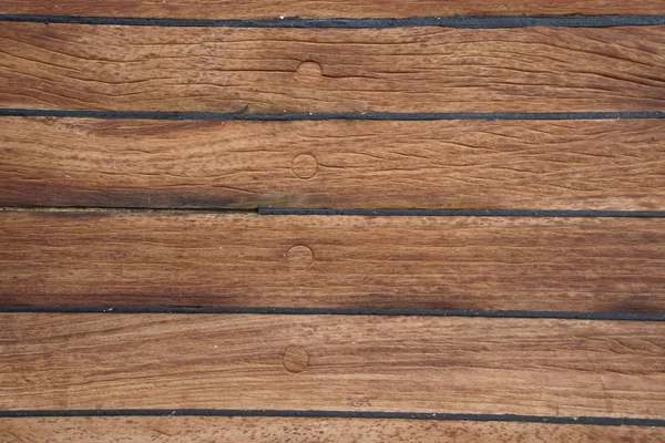 The deck is on the ship. wood texture. surface. brown.