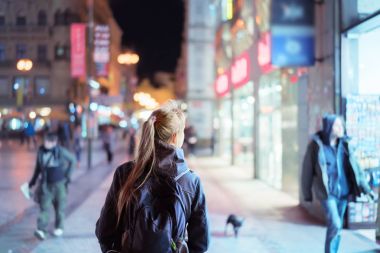 Gece vakti şehir caddesinde yürüyen kızın arka görüntüsü, Prag
