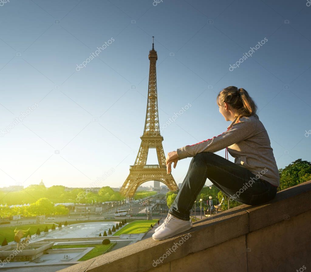 girl looking at the Eiffel tower in sunrise time, Paris