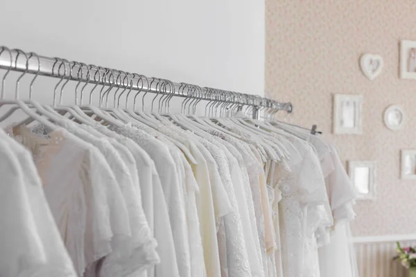 Interieur van bruids salon. Prachtige trouwjurk op een hangers. Stockfoto