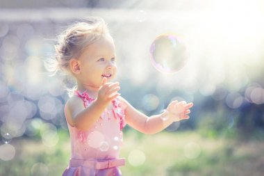 Küçük bir kız sabun köpüğü yaz Park yakalar