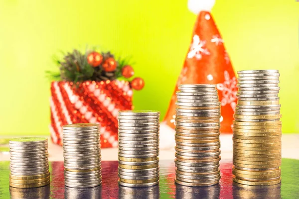 Business Finance and money concept. Five growing stacks count coins. Standing on wooden table  bright background. New year cap of Santa Claus, gift for Christmas Stock Image