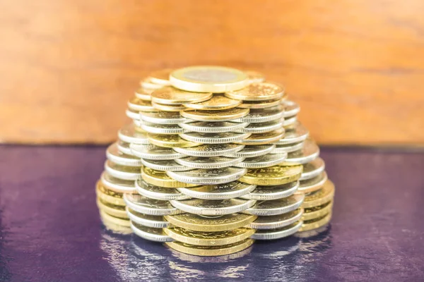 The pyramids of gold and silver coins on brown blurred background. Business concept finance. Royalty Free Stock Photos