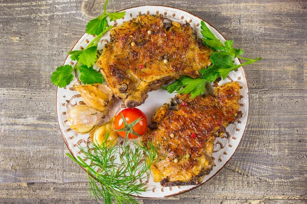 Carne frita em uma chapa com tomates e ervas, pimentas. A comida a mesa de madeira, fundo cinza . — Fotografia de Stock