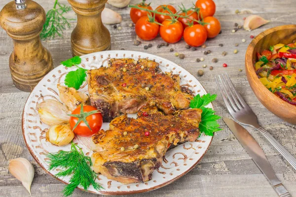 Carne assada, tomates, pimentas, cebolas legumes fatiados em um prato branco de corte Tabuleiro com garfo e faca, especiarias alho vista superior fechar derevna a mesa. Fundo cinzento — Fotografia de Stock