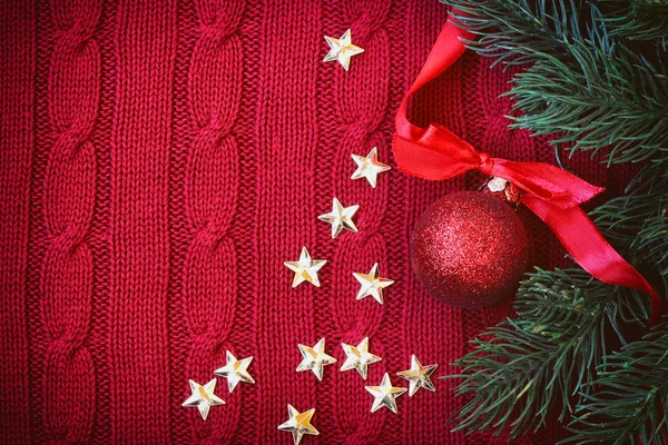 Christmas red knitted background with branch fir