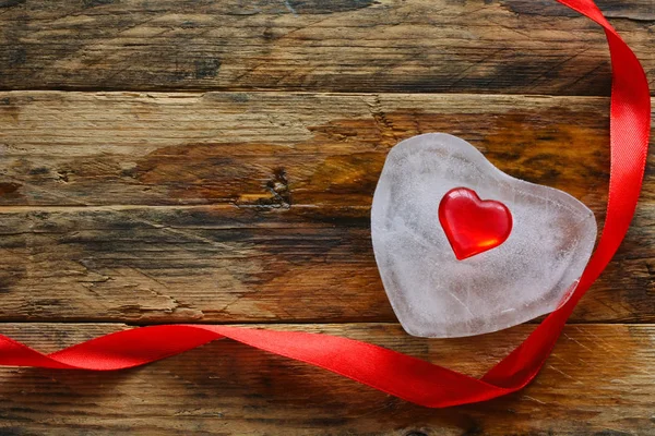 Derretimiento corazón de hielo, cinta roja de seda —  Fotos de Stock
