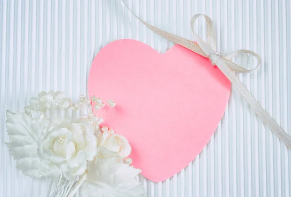 Бутоньєрка, тег у формі рожевого серця, біла шовкова стрічка — стокове фото