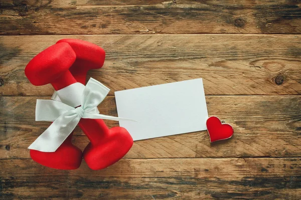 Dos mancuerna roja con un arco de regalo y etiqueta de papel en blanco Fotos de stock libres de derechos