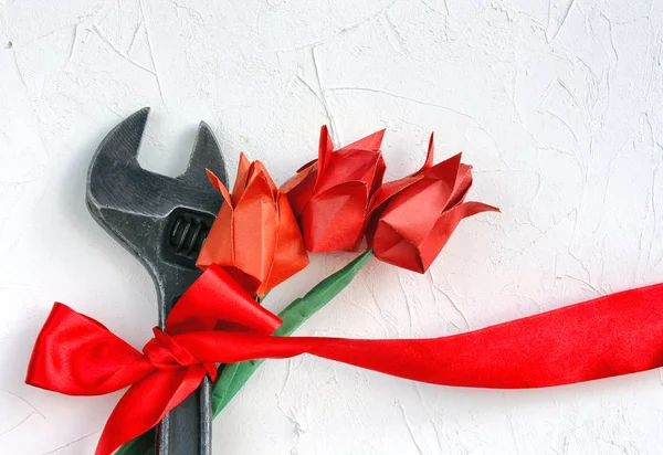 1 травня концепція, гайковий ключ з червоною стрічкою та орігамі тюльпан — стокове фото