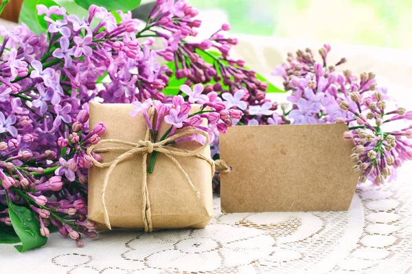 Violet Lila boeket, kleine geschenk doos en papieren label — Stockfoto