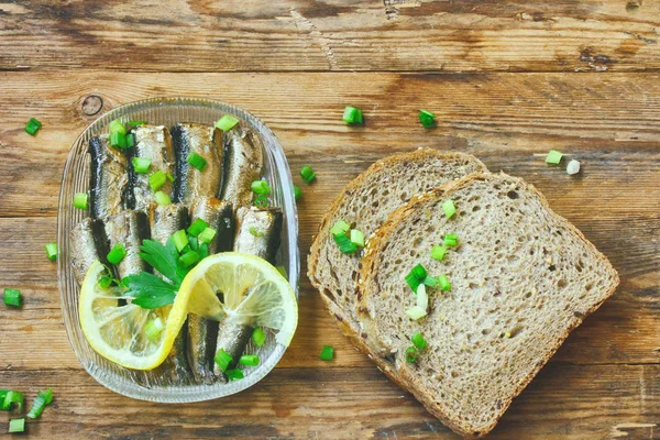 烟熏鲱鱼油玻璃盘、 绿洋葱、 柠檬、 面包 — 图库照片