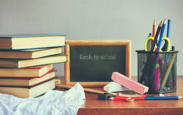 Stapel van schoolboeken, school accessoires op houten tafel — Stockfoto