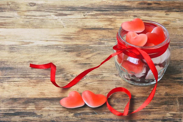 나무 테이블에 유리 용기에 젤리 사탕 모양 심장 — 스톡 사진