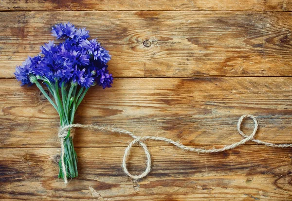 Zomer boeket van korenbloemen met touw op houten tafel — Stockfoto