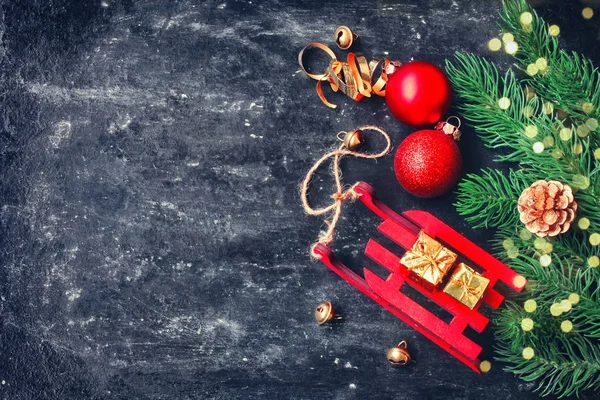 Holiday jul svart shabby bakgrund, röd släde leksak, bollar, — Stockfoto