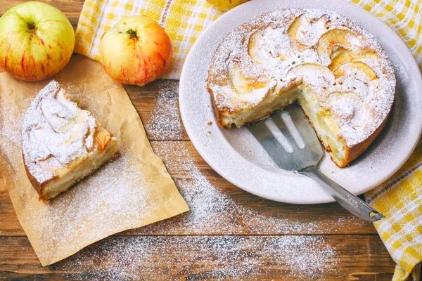 Homemade apple pie on plate sprinkled with powdered sugar, piece — Stock Photo, Image