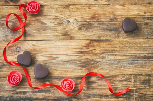 Tarjeta de felicitación del día de San Valentín, forma de corazón de chocolate con leche, rosa — Foto de Stock