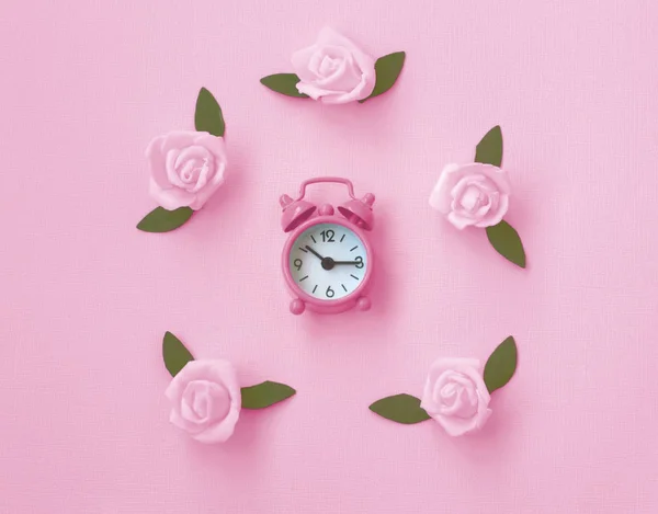 Gentle pink paper texture background with alarm clock, rose — Stock Photo, Image