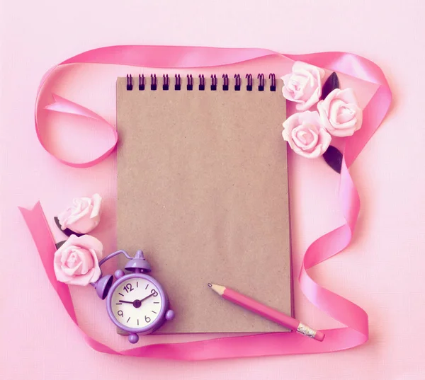 Spring pink background with alarm clock, rose flowers, pencil, n — Stock Photo, Image