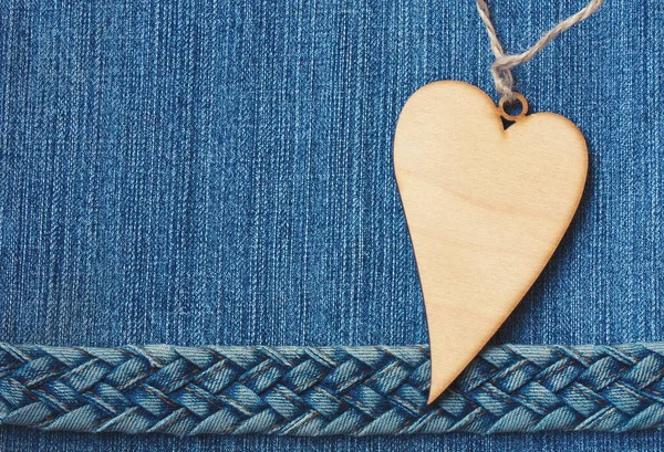 Blue denim background, jeans braided belt, wooden heart — Stock Photo, Image