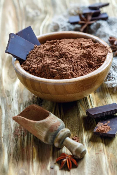 Cocoa powder and dark chocolate in a wooden bowl.